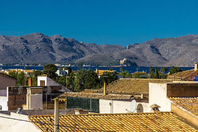 High angle view of townscape and mountains against blue sky