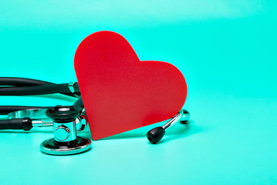 Close-up of heart shape on table against blue background