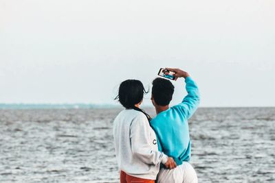 Rear view of man photographing sea