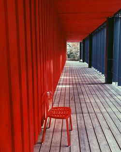 Empty chairs on footpath by building