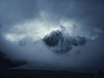 Scenic view of sea and snowcapped mountains against sky