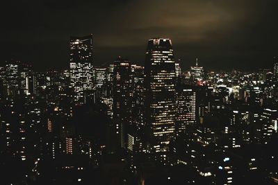 Illuminated buildings in city against sky at night