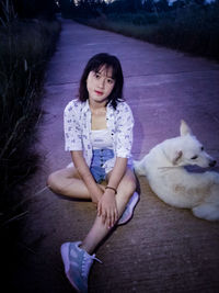 Full length of a young woman sitting outdoors