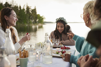 Family having dinner by lake