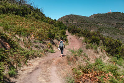 Rear view of person walking on footpath