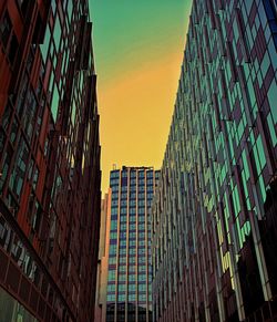 Low angle view of modern buildings against sky during sunset