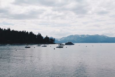 Scenic view of lake and mountains against cloudy sky