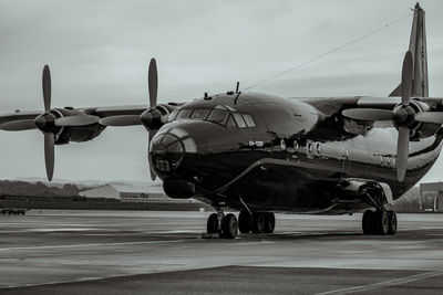 Airplane on airport runway against sky