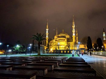 Illuminated mosque in city at night