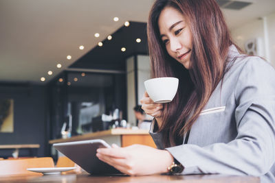 Midsection of woman holding coffee cup