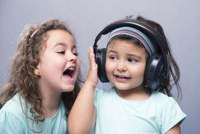 Close-up of girl listening music with sister