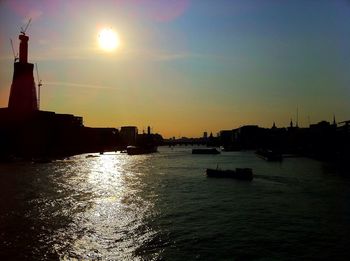 Boats in river at sunset
