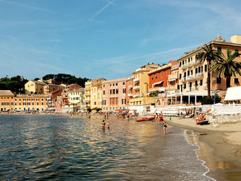 Buildings by sea against sky in city