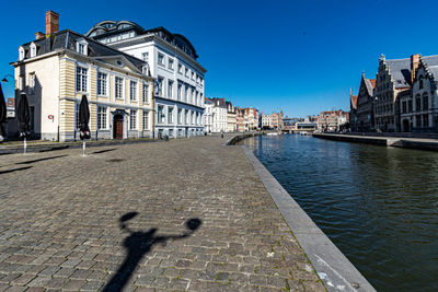 People on street by buildings against sky in city