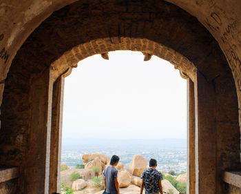 Rear view of people looking at archway