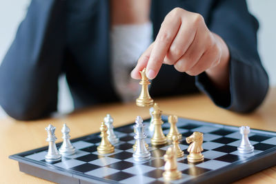 Midsection of businesswoman playing with chess at desk