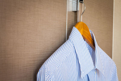 Cropped image of shirt hanging on cabinet