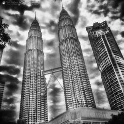 Low angle view of modern buildings against cloudy sky