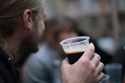 Close-up of man having beer outdoors