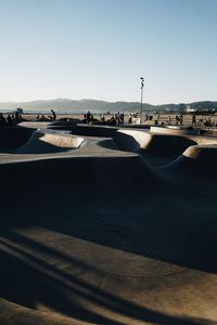 Skateboard park in city against clear blue sky