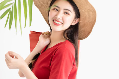 Portrait of smiling young woman against white background