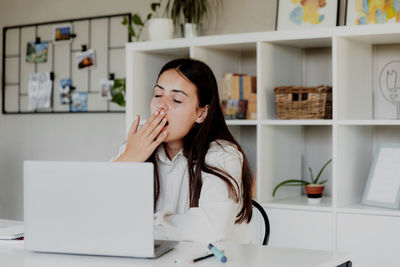 Young woman using laptop at home