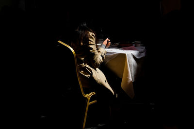 Rear view of woman sitting on chair