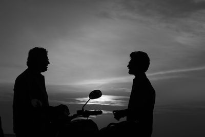 Silhouette people standing against sky during sunset