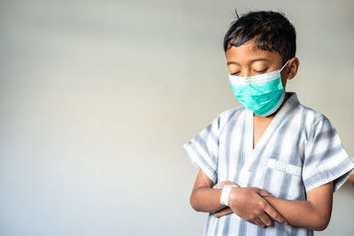 Boy standing against white background