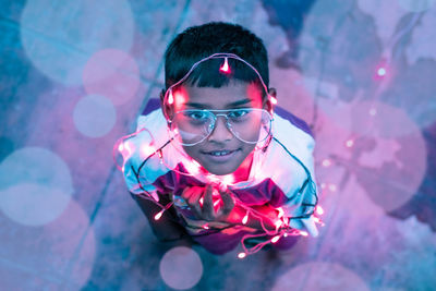 Portrait of boy wearing illuminated string light