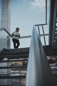 Low angle view of man standing on staircase in building