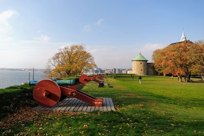 Cannons on field at fortress against sky during autumn