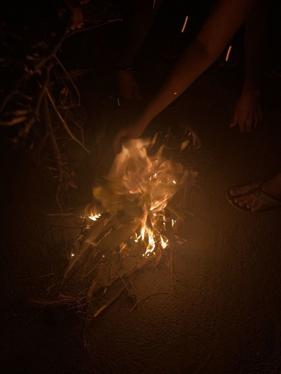 LOW SECTION OF WOMAN WITH FIRE IN BACKGROUND