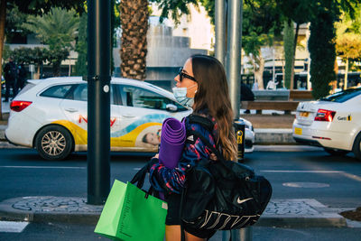 Woman with umbrella on street in city