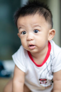 Close-up of cute boy looking away while sitting at home