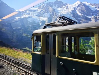 Railroad tracks by mountain against sky