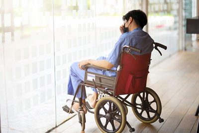 Patient sitting on wheelchair by window at hospital