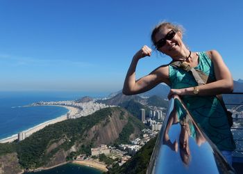 Smiling young woman showing bicep at observation point