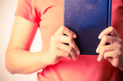 Midsection of woman holding book