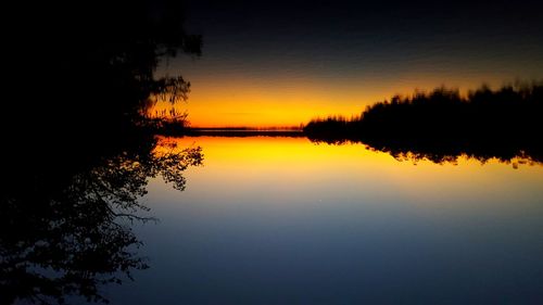 Scenic view of lake against sky at sunset
