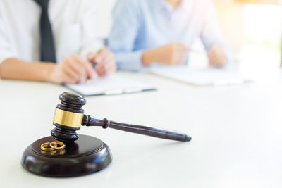 Close-up of gavel with lawyers in background