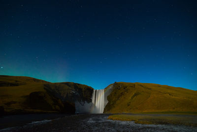 Scenic view of waterfall against clear sky at night