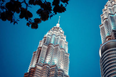 Low angle view of building against clear blue sky. klcc during the night.