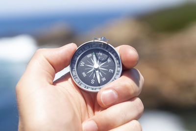 Close-up of hand holding navigational compass