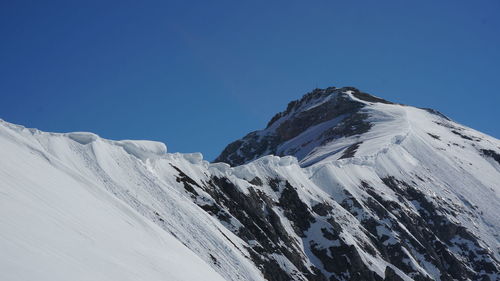 Scenic view of snowcapped mountains against clear blue sky