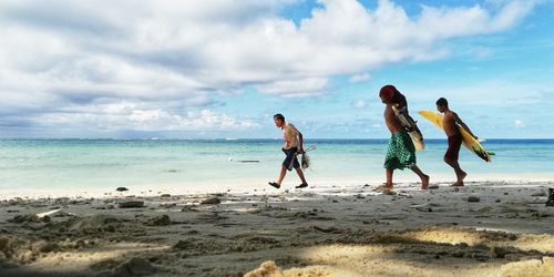 People on beach against sky