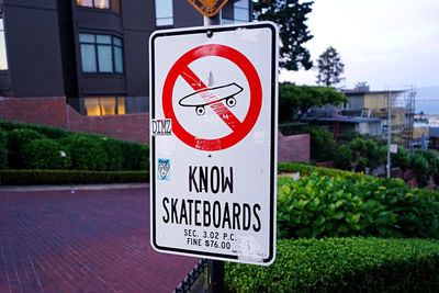 Close-up of road sign against sky