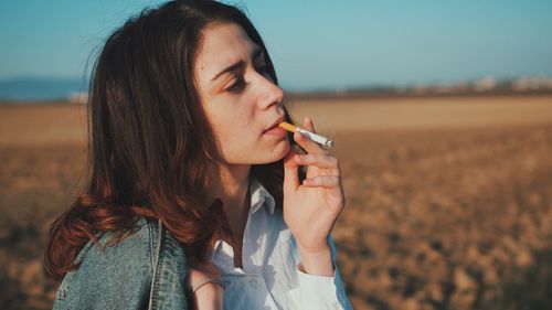 Portrait of woman holding cigarette