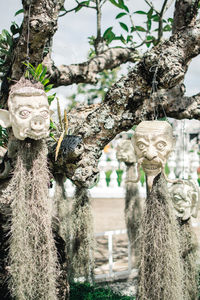 Close-up of statue against tree trunk