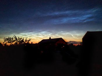 Silhouette buildings against sky at dusk